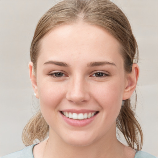 Joyful white young-adult female with medium  brown hair and grey eyes