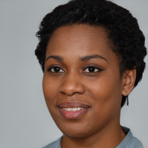 Joyful black young-adult female with short  black hair and brown eyes