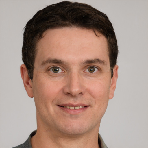 Joyful white adult male with short  brown hair and grey eyes