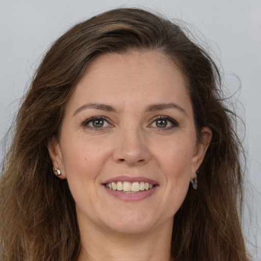 Joyful white adult female with long  brown hair and brown eyes