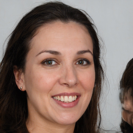 Joyful white young-adult female with long  brown hair and brown eyes