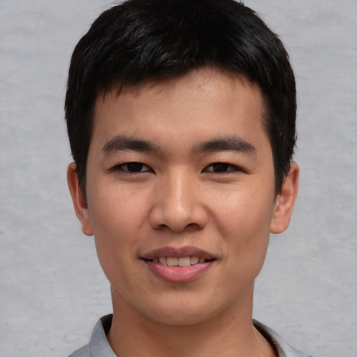 Joyful asian young-adult male with short  black hair and brown eyes