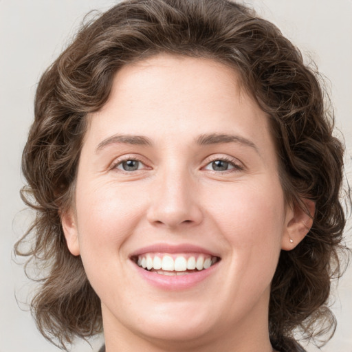 Joyful white young-adult female with medium  brown hair and green eyes