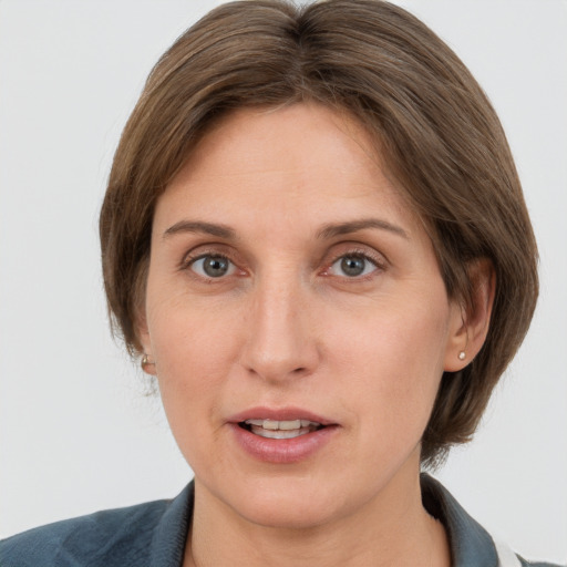 Joyful white adult female with medium  brown hair and grey eyes