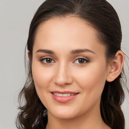 Joyful white young-adult female with long  brown hair and brown eyes