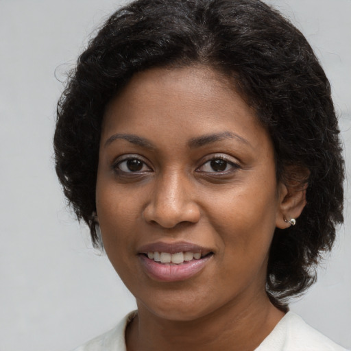 Joyful black young-adult female with long  brown hair and brown eyes