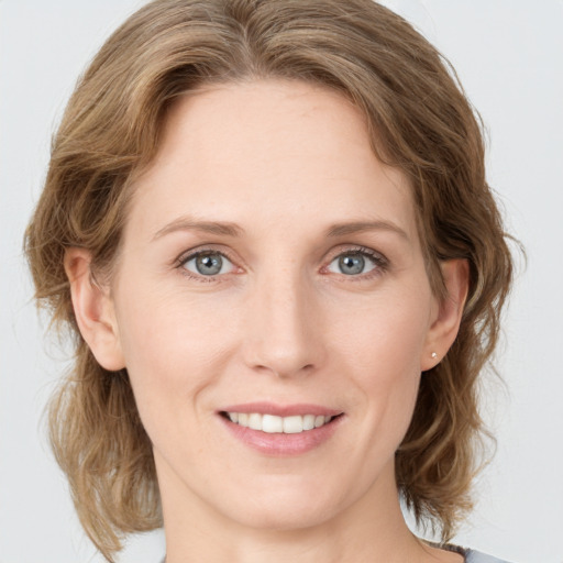 Joyful white young-adult female with medium  brown hair and grey eyes