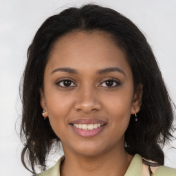 Joyful black young-adult female with long  brown hair and brown eyes