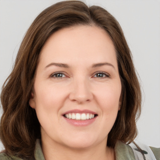 Joyful white young-adult female with medium  brown hair and green eyes