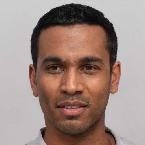 Joyful latino young-adult male with short  black hair and brown eyes