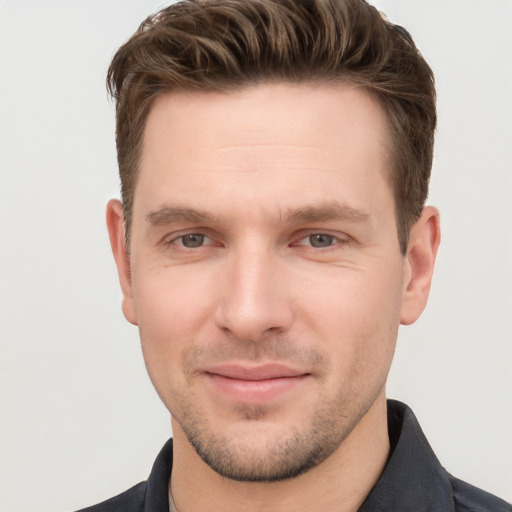 Joyful white young-adult male with short  brown hair and grey eyes