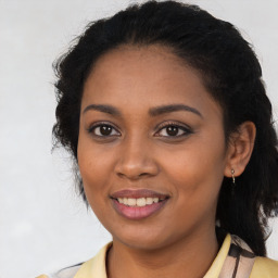 Joyful black young-adult female with long  brown hair and brown eyes