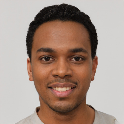 Joyful black young-adult male with short  black hair and brown eyes