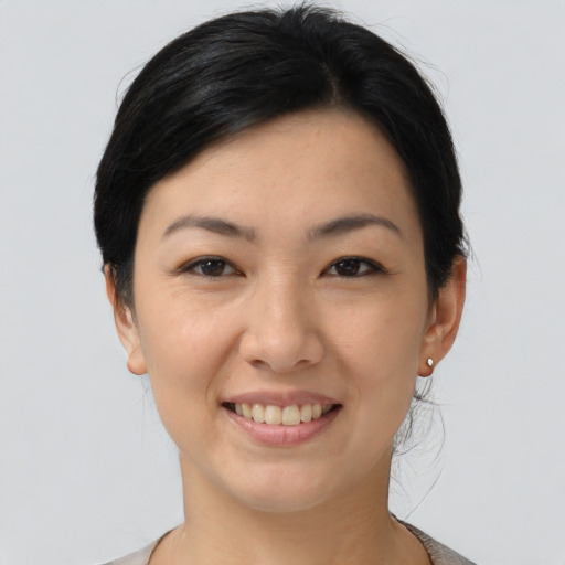 Joyful asian young-adult female with short  black hair and brown eyes