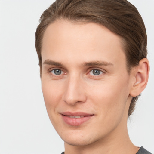 Joyful white young-adult male with short  brown hair and grey eyes