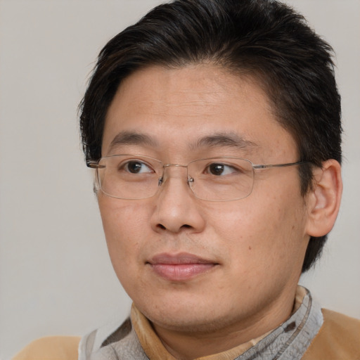 Joyful asian adult male with short  brown hair and brown eyes