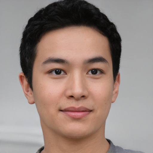 Joyful asian young-adult male with short  black hair and brown eyes