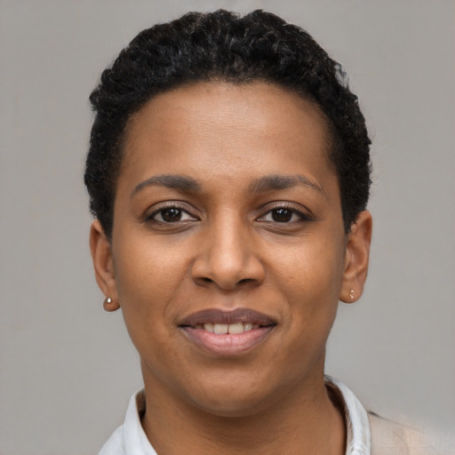 Joyful black young-adult female with short  black hair and brown eyes