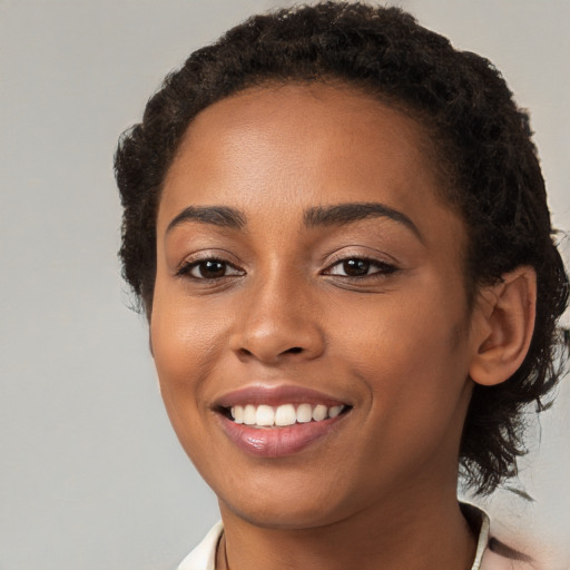 Joyful black young-adult female with short  brown hair and brown eyes