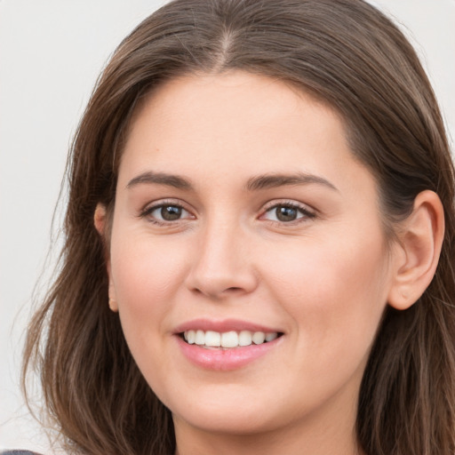 Joyful white young-adult female with long  brown hair and grey eyes