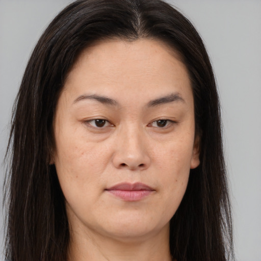 Joyful asian young-adult female with long  brown hair and brown eyes