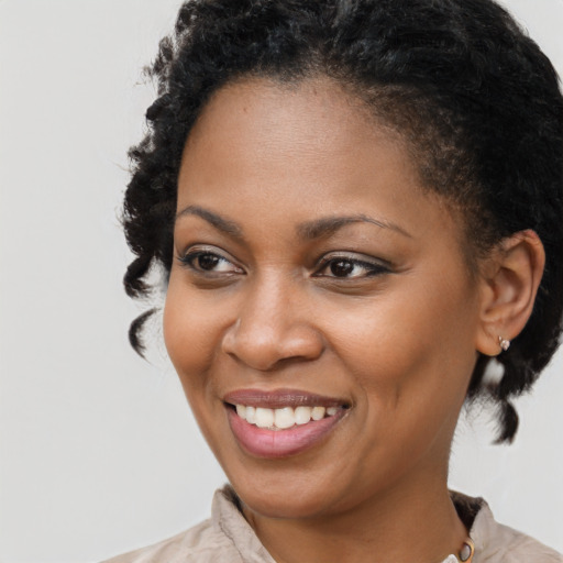 Joyful black young-adult female with short  brown hair and brown eyes