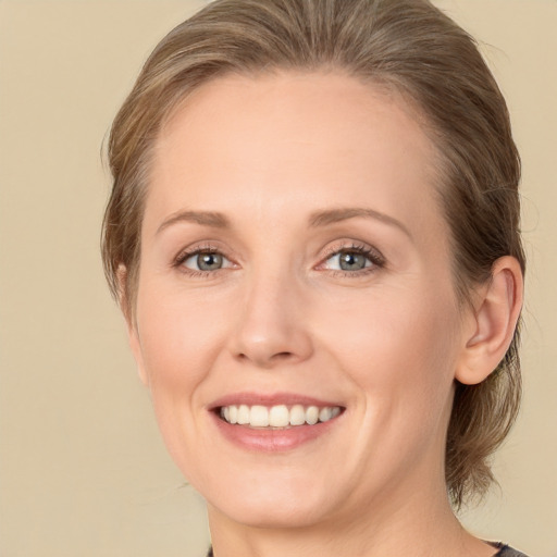 Joyful white young-adult female with medium  brown hair and green eyes