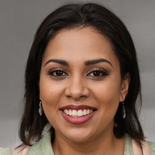 Joyful latino young-adult female with medium  brown hair and brown eyes