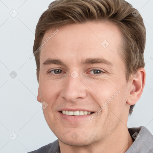 Joyful white young-adult male with short  brown hair and grey eyes