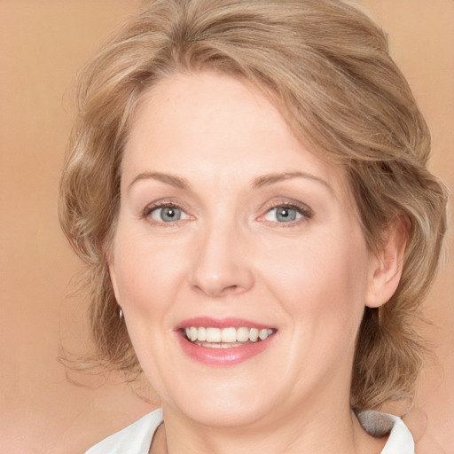 Joyful white adult female with medium  brown hair and blue eyes