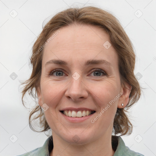 Joyful white adult female with medium  brown hair and grey eyes