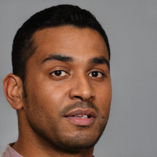 Joyful black young-adult male with short  brown hair and brown eyes