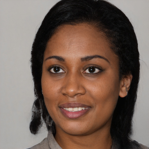 Joyful black young-adult female with long  black hair and brown eyes