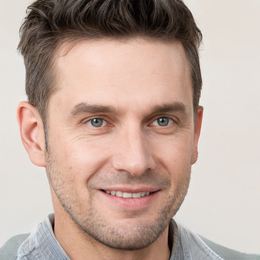 Joyful white adult male with short  brown hair and brown eyes