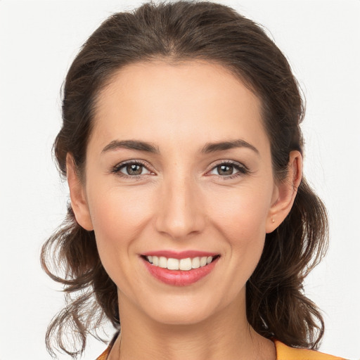 Joyful white young-adult female with long  brown hair and brown eyes