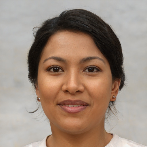 Joyful latino young-adult female with medium  brown hair and brown eyes