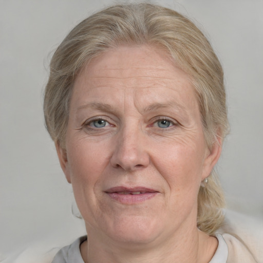 Joyful white middle-aged female with medium  blond hair and blue eyes