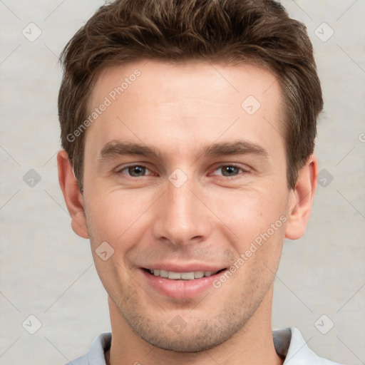 Joyful white young-adult male with short  brown hair and grey eyes