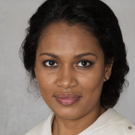 Joyful black adult female with medium  brown hair and brown eyes