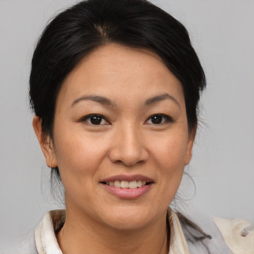 Joyful asian adult female with medium  brown hair and brown eyes
