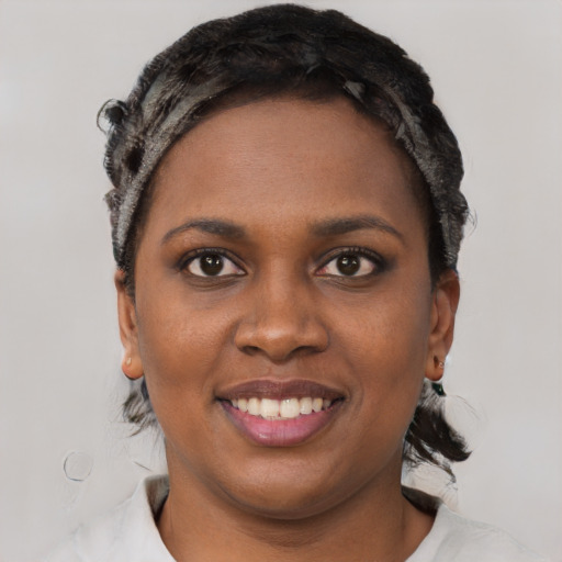 Joyful black young-adult female with short  black hair and brown eyes