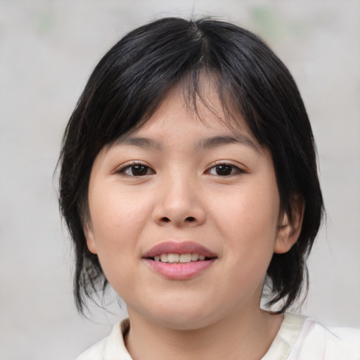 Joyful asian child female with medium  brown hair and brown eyes