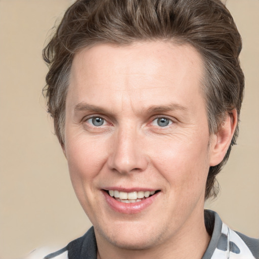 Joyful white adult male with medium  brown hair and grey eyes