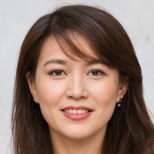 Joyful white young-adult female with long  brown hair and brown eyes