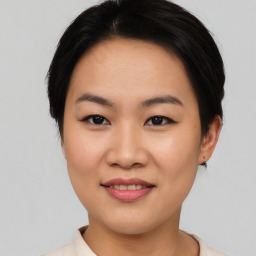 Joyful asian young-adult female with short  black hair and brown eyes