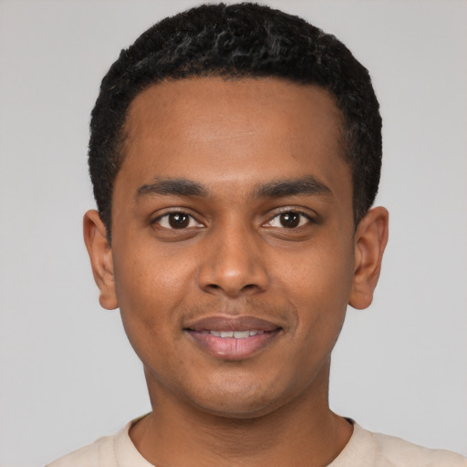 Joyful black young-adult male with short  black hair and brown eyes