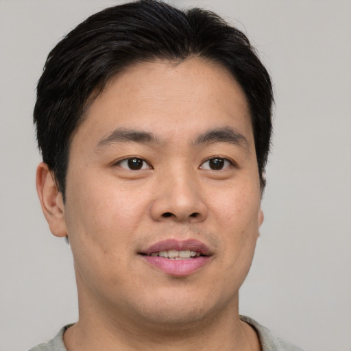 Joyful asian young-adult male with short  brown hair and brown eyes