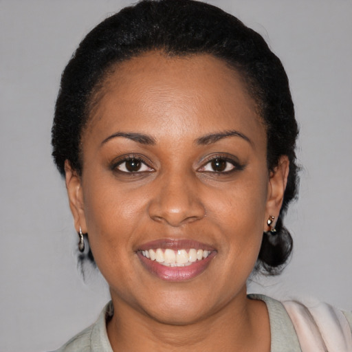 Joyful black young-adult female with medium  black hair and brown eyes