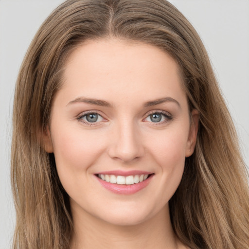 Joyful white young-adult female with long  brown hair and grey eyes