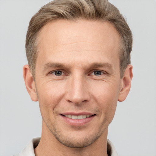 Joyful white adult male with short  brown hair and grey eyes